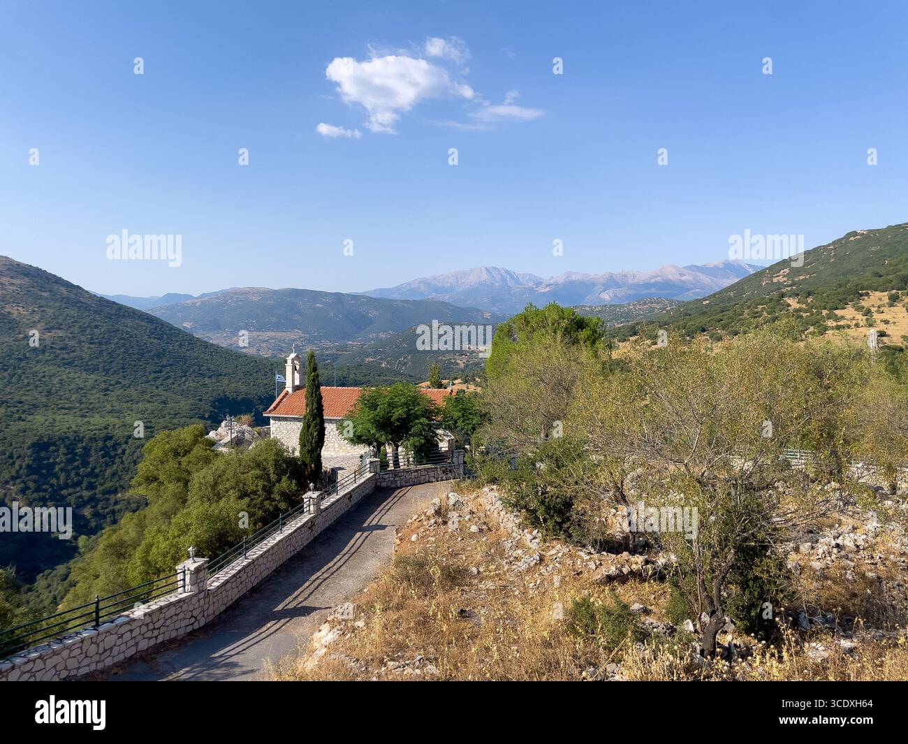 Kirche Saint Demetrios mit Blick auf die bergige Landschaft des Dorfes Drakovouni in Arcadia, Peloponnes, Griechenland, an einem klaren Sommertag - Smartphone-aufgenommenes Stockfoto