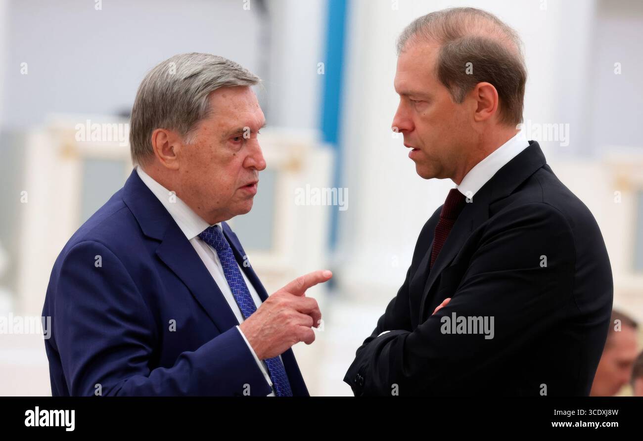 Moskau, Russland. August 2025. Der russische Präsidentschaftshelfer Jury Uschakow, links, und der erste stellvertretende Premierminister Denis Manturow, rechts, sprechen vor dem Beginn eines Treffens unter dem Vorsitz von Präsident Wladimir Putin im Kreml am 14. August 2025 in Moskau, Russland. Das Treffen ist in Vorbereitung auf das bevorstehende US-russische Gipfeltreffen in Alaska. Quelle: Vyacheslav Prokofyev/Kreml Pool/Alamy Live News Stockfoto