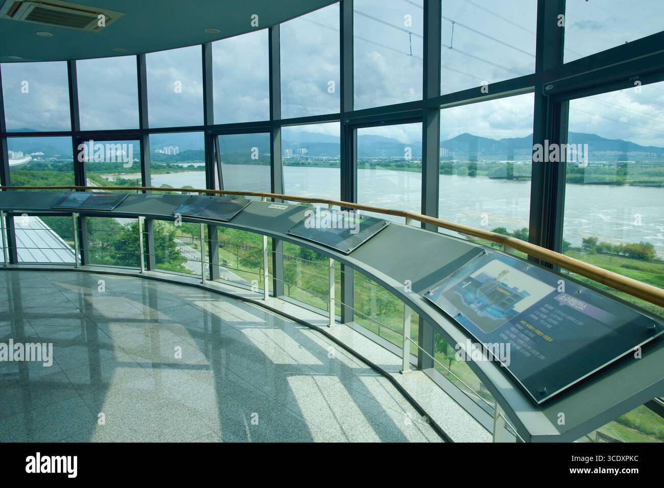 Ein Ring von Interpretationstafeln säumt den Beobachtungsraum, der über den Nakdong-Fluss und Feuchtgebiete in Richtung Bergrücken zeigt und einen Kontext bietet Stockfoto