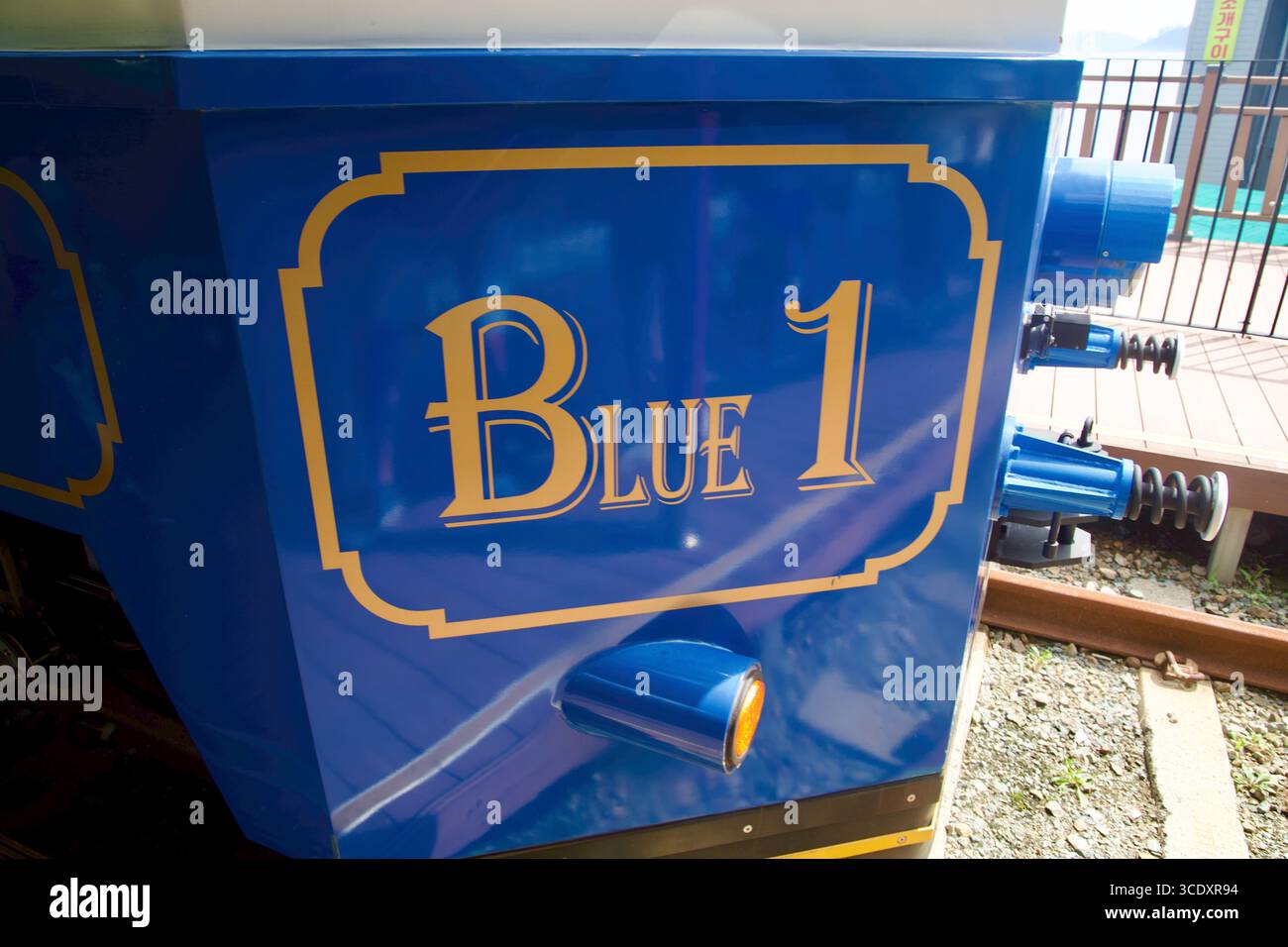Aus nächster Nähe das „Blue 1“-Emblem und die Zierleiste des Haeundae Beach Train Wagens, die den dekorativen goldenen Schriftzug auf blauer Farbe in der Nähe des Nars hervorhebt Stockfoto