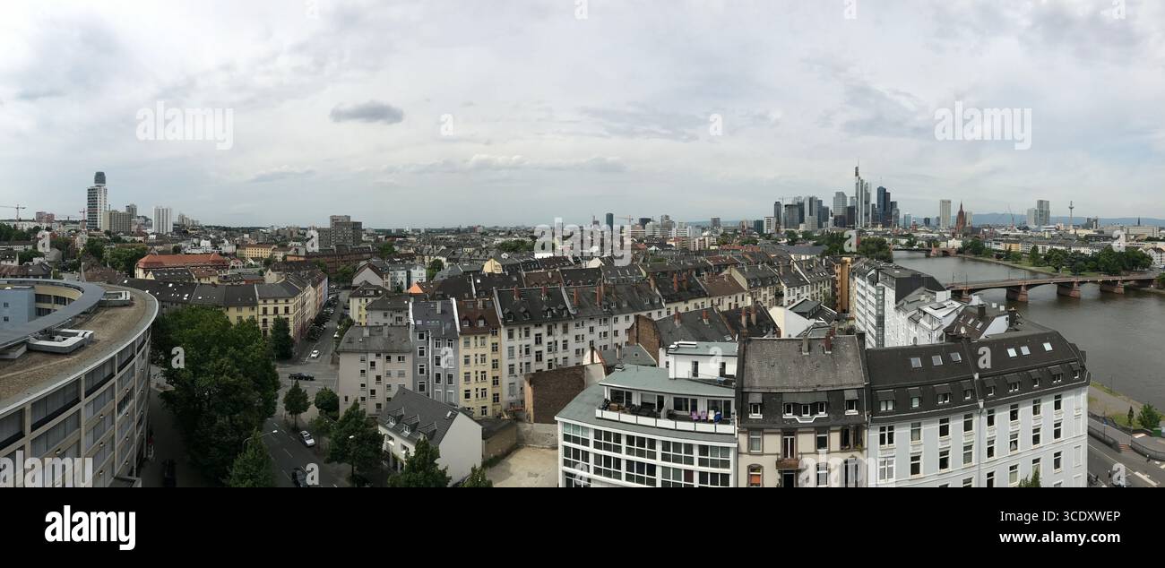 Breiter Panoramablick auf eine Stadt mit einer Mischung aus historischer und moderner Architektur, einem fließenden Fluss und einem bewölkten Himmel, der die städtische Entwicklung und den Blick zeigt Stockfoto
