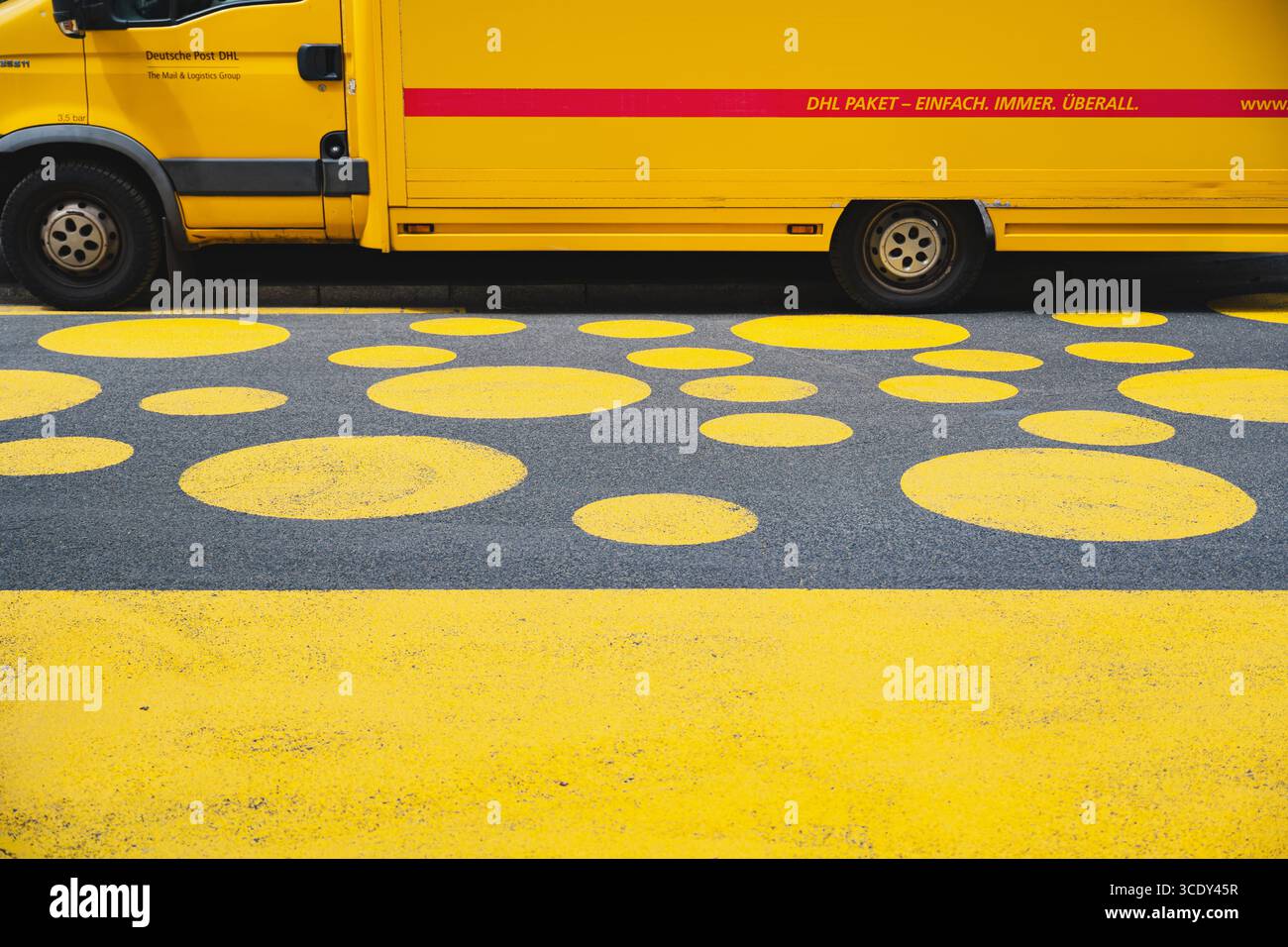 DHL-Lieferwagen parkte auf einer Straße mit gelbem Kreis Road Art Stockfoto
