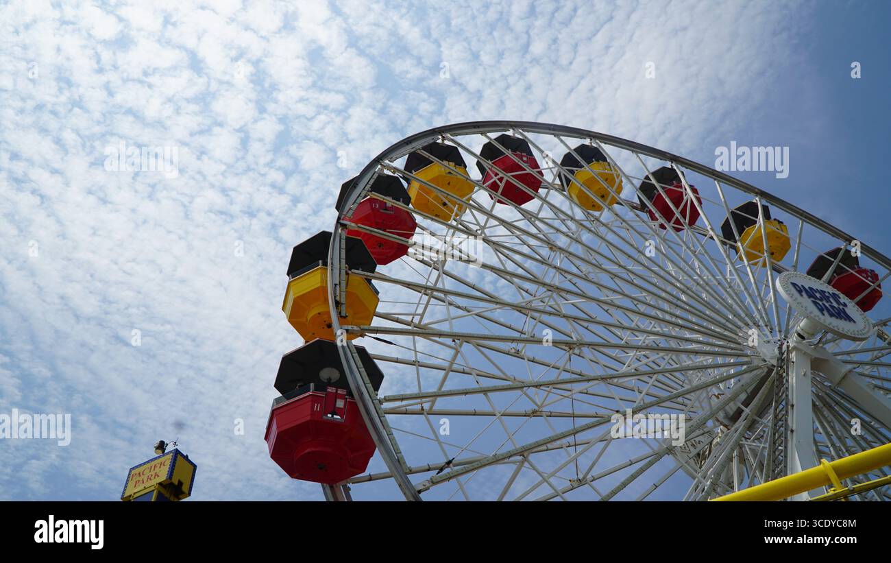 Farbenfrohe Riesenradfahrt im Pacific Park Vergnügungspark am Santa Monica Pier, Los Angeles, Kalifornien, USA, mit einem strahlend blauen Himmel Stockfoto