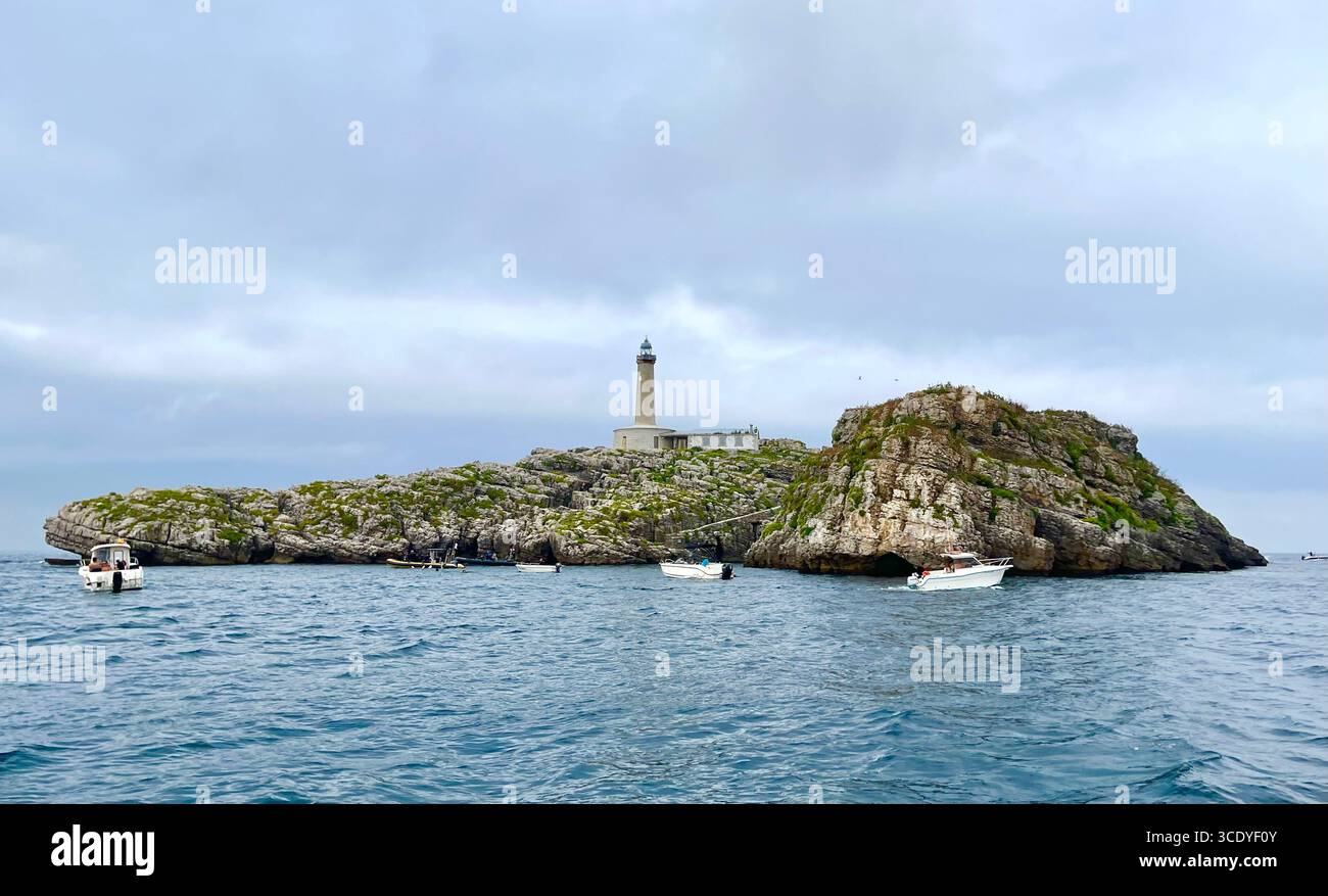 Automatisierter Leuchtturm auf der unbewohnten Insel Mouro mit kleinen Booten vor Anker am Eingang zur Bucht von Santander Cantabria Spanien Europa - Smartphone-aufgenommenes Stockfoto