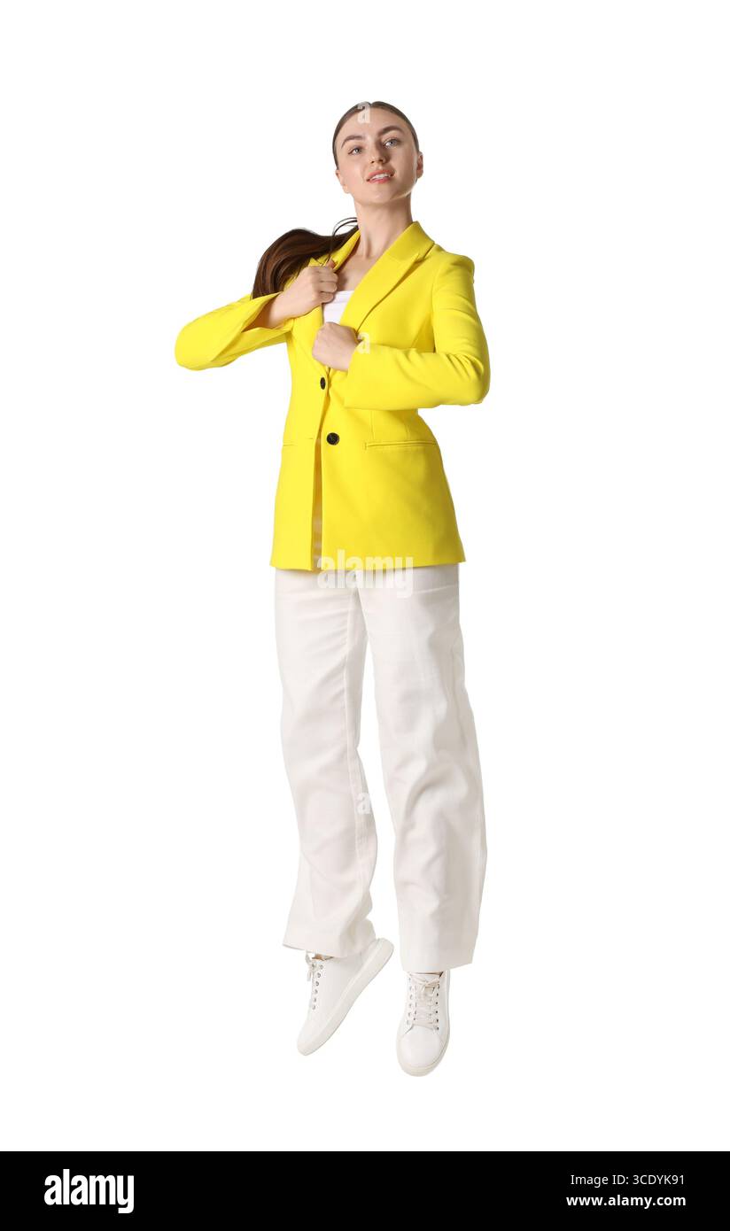 Frau in gelber Jacke, die auf weißem Hintergrund springt Stockfoto