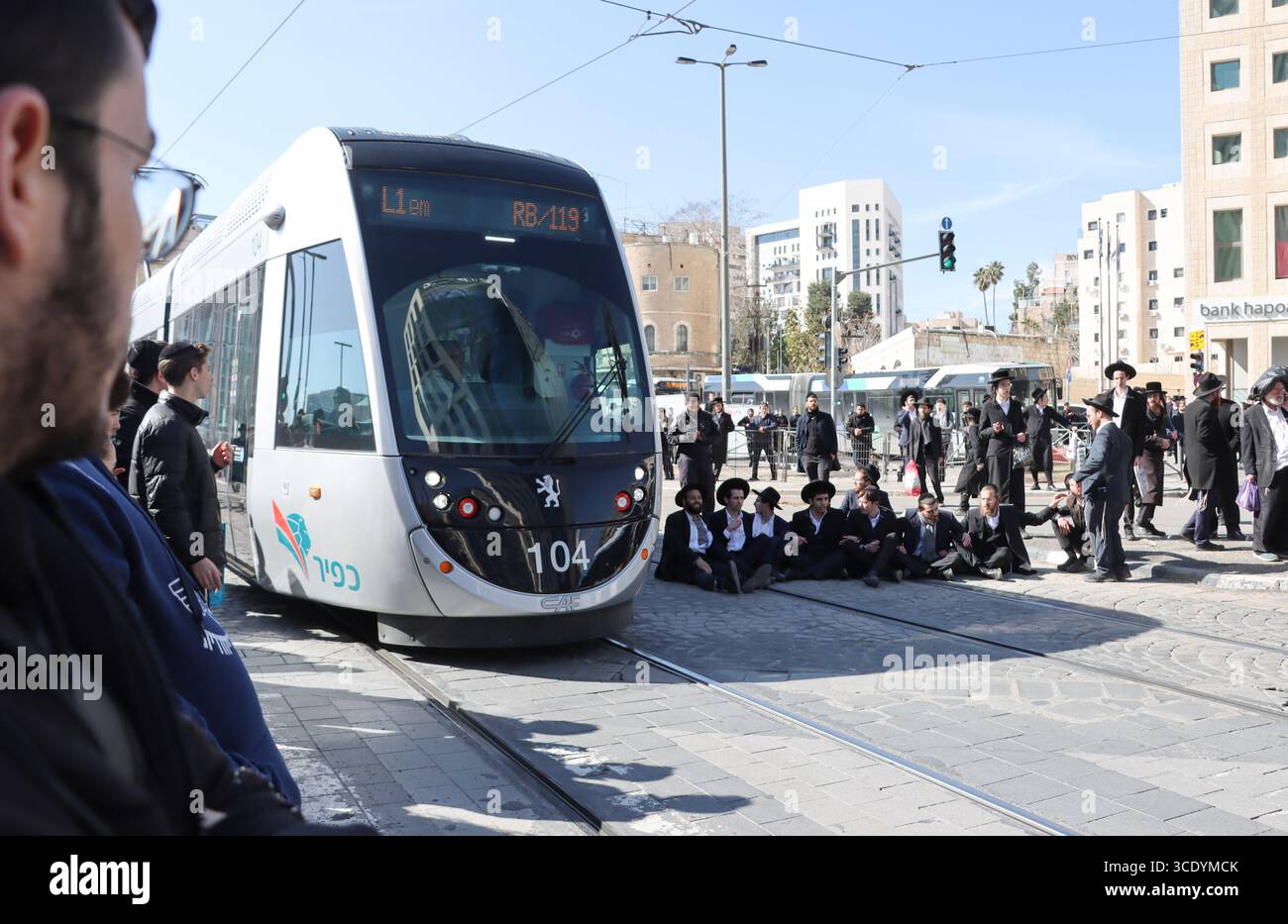 Ultra-orthodoxe Juden protestieren gegen einen IDF-Entwurf und blockieren die Stadtbahn entlang der Jaffa Street in Jerusalem am 25. Februar 2025. Stockfoto