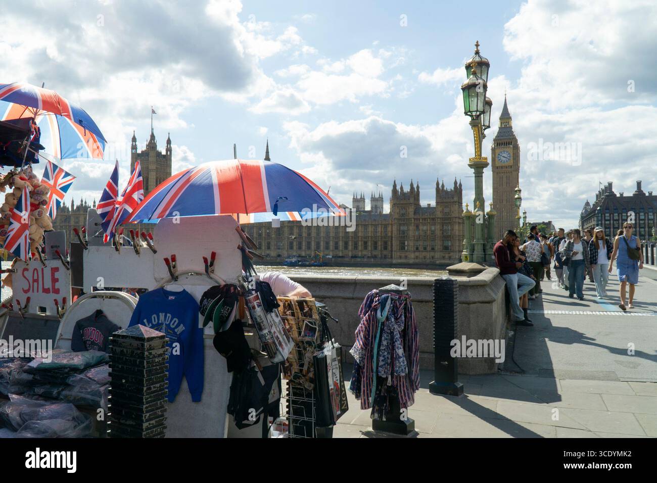 Großbritannien Wetter, 14. August 2025: Als die Temperaturen im Zentrum Londons wieder 27 Grad erreichten, verkauft ein Souvenirstand an der Westminster Bridge union Jack Flags, Regenschirme und Teddybären, mit dem Elizabeth Tower of the Houses of Parliament (der Big Ben beherbergt). Quelle: Anna Watson/Alamy Live News Stockfoto