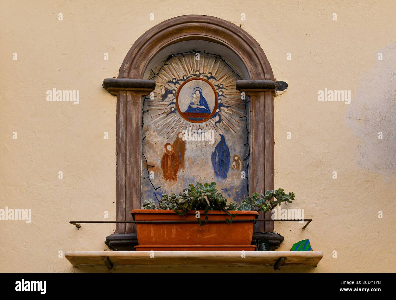 Votivschrein mit Madonna und Kind umgeben von Engeln und Gläubigen an der Fassade eines alten Gebäudes in der Altstadt, Sanremo, Ligurien, Italien Stockfoto