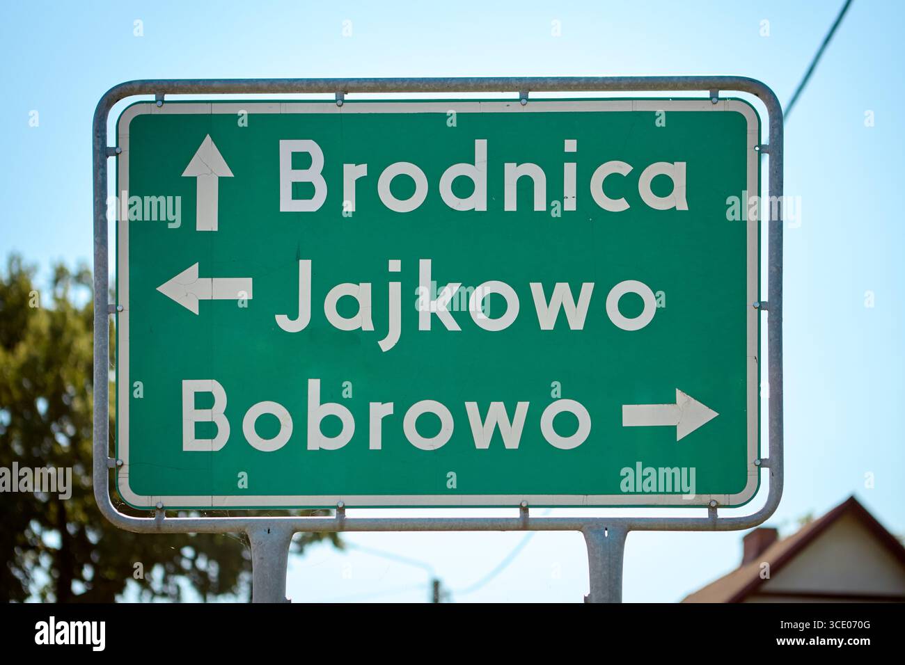 Grünes Richtungsschild mit weißem Text und Pfeilen, die in Richtung Brodnica, Jajkowo und Bobrowo zeigen und Fahrern in der Sonne eine Orientierungshilfe bieten Stockfoto