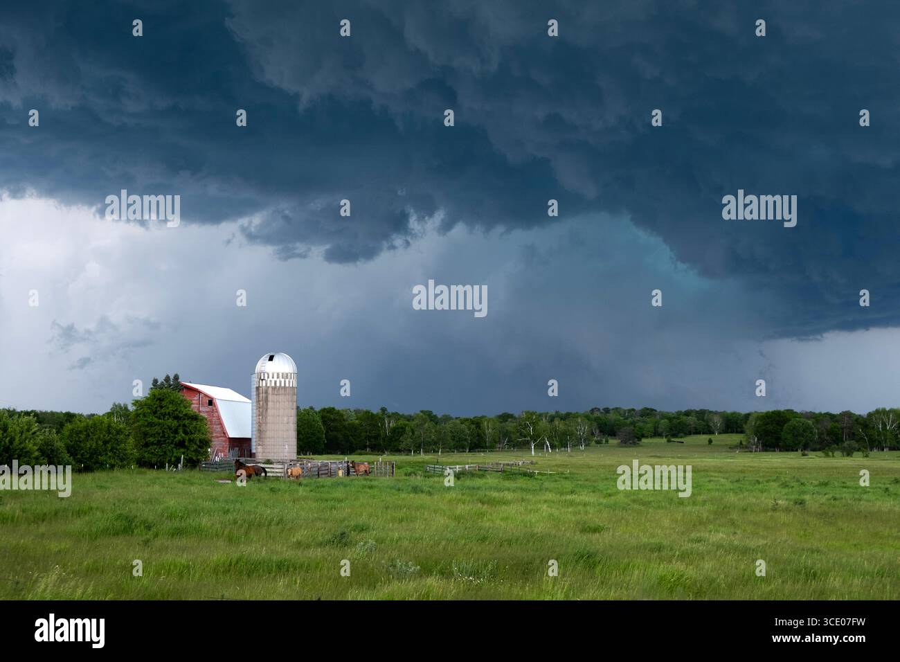 Dramatische schwere Gewitter über einer Scheune und einem Silo im ländlichen Cass County, Minnesota Stockfoto