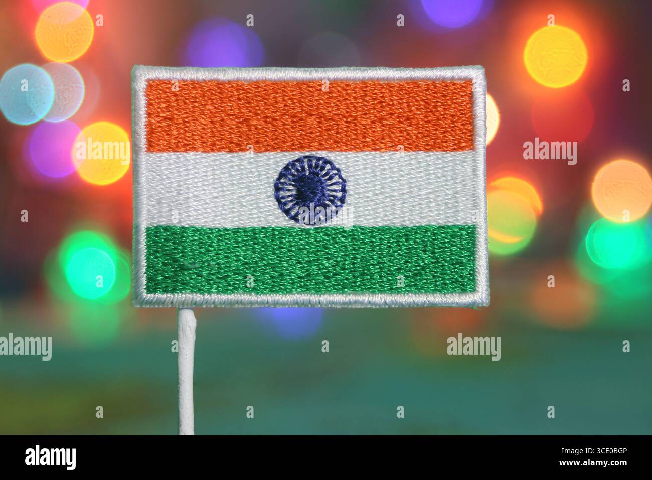 Gestickte indische Flagge mit Regenbogenbokeh, das an Feuerwerk erinnert, festliches Konzept für Nationalfeier oder Neujahrsfeier. Stockfoto