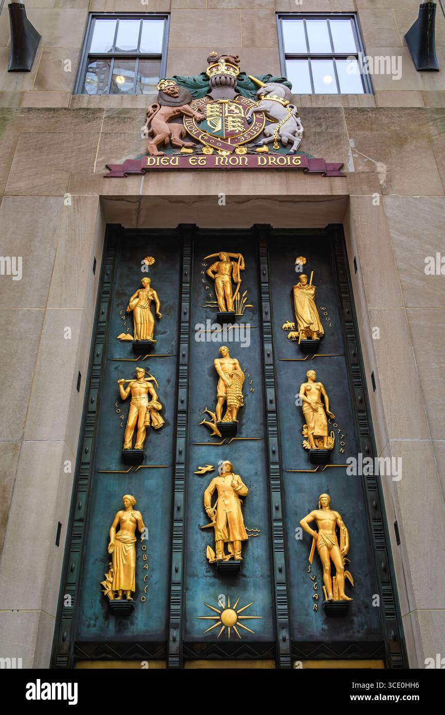 New York, USA - 1. Dezember 2023: Verzierte Bronzetür des British Empire Building im Rockefeller Center mit königlichem Wappen und vergoldeten Reliefs Stockfoto
