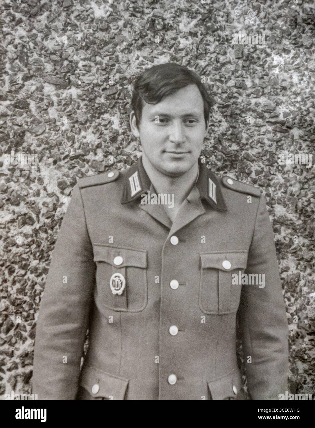 DDR (DDR/DDR) um 1974: Porträt eines jungen Soldaten der Nationalen Volksarmee (abgekürzt NVA) posiert für die Kamera in der typischen Uniform der frühen 1970er Jahre Jeder berechtigte Mann in der DDR musste 18 Monate lang einen Wehrdienst absolvieren Stockfoto