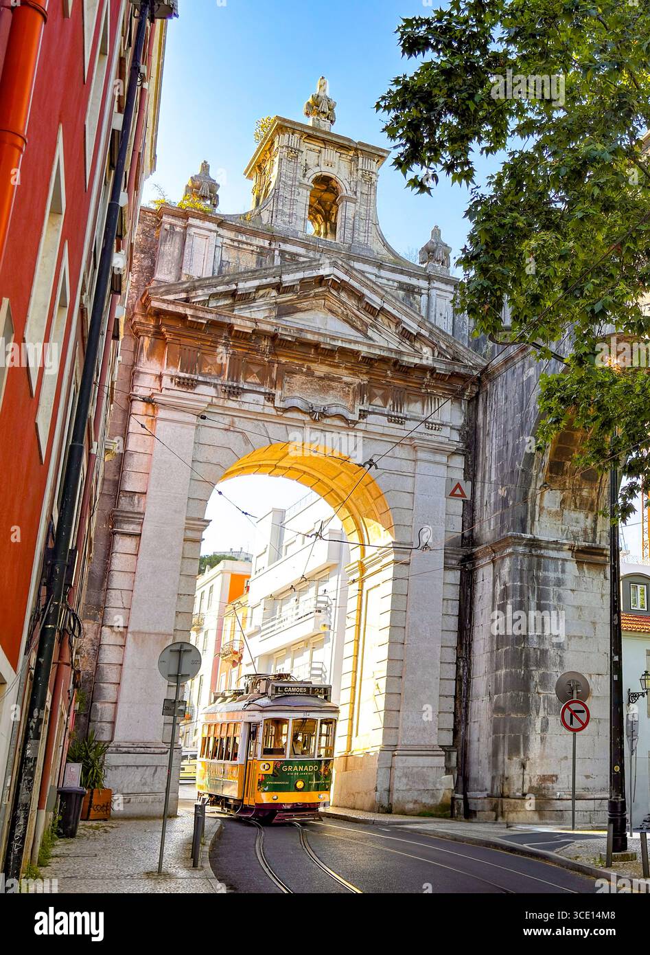 Historische Straßenbahn 24E, die unter dem Arco Triunfal das Amoreiras in der Nähe von Rato, Lissabon, Portugal, vorbeiführt – ein Wahrzeichen des Bogens und der berühmten Stadtszene. Stockfoto