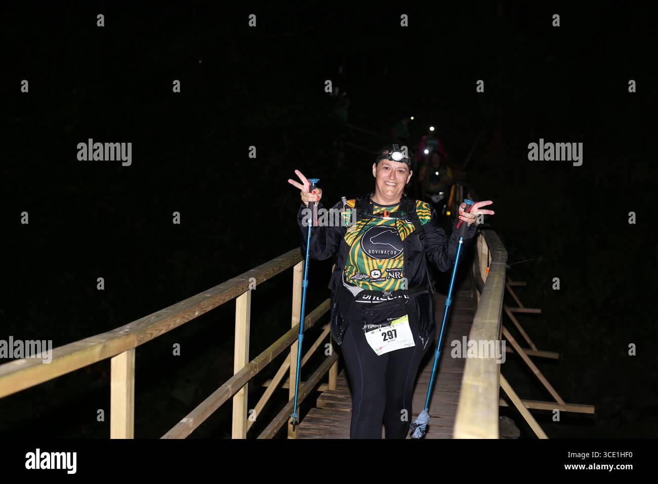 Teilnehmer auf der beleuchteten Brücke während des Furnas Night Trail Events auf den Azoren Stockfoto