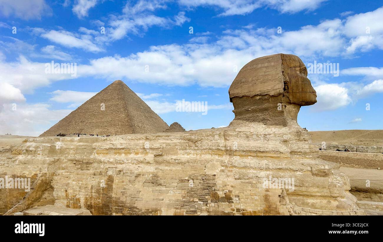Die große Sphinx von Gizeh mit der berühmten Großen Pyramide im Hintergrund, ein zeitloser Blick auf die altägyptische Pracht. Stockfoto