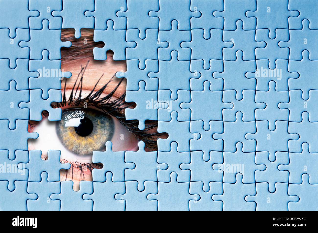 Nahaufnahme des menschlichen Auges, der durch fehlende Puzzleteile schaut, Konzept der Neugier und des Geheimnisses Stockfoto