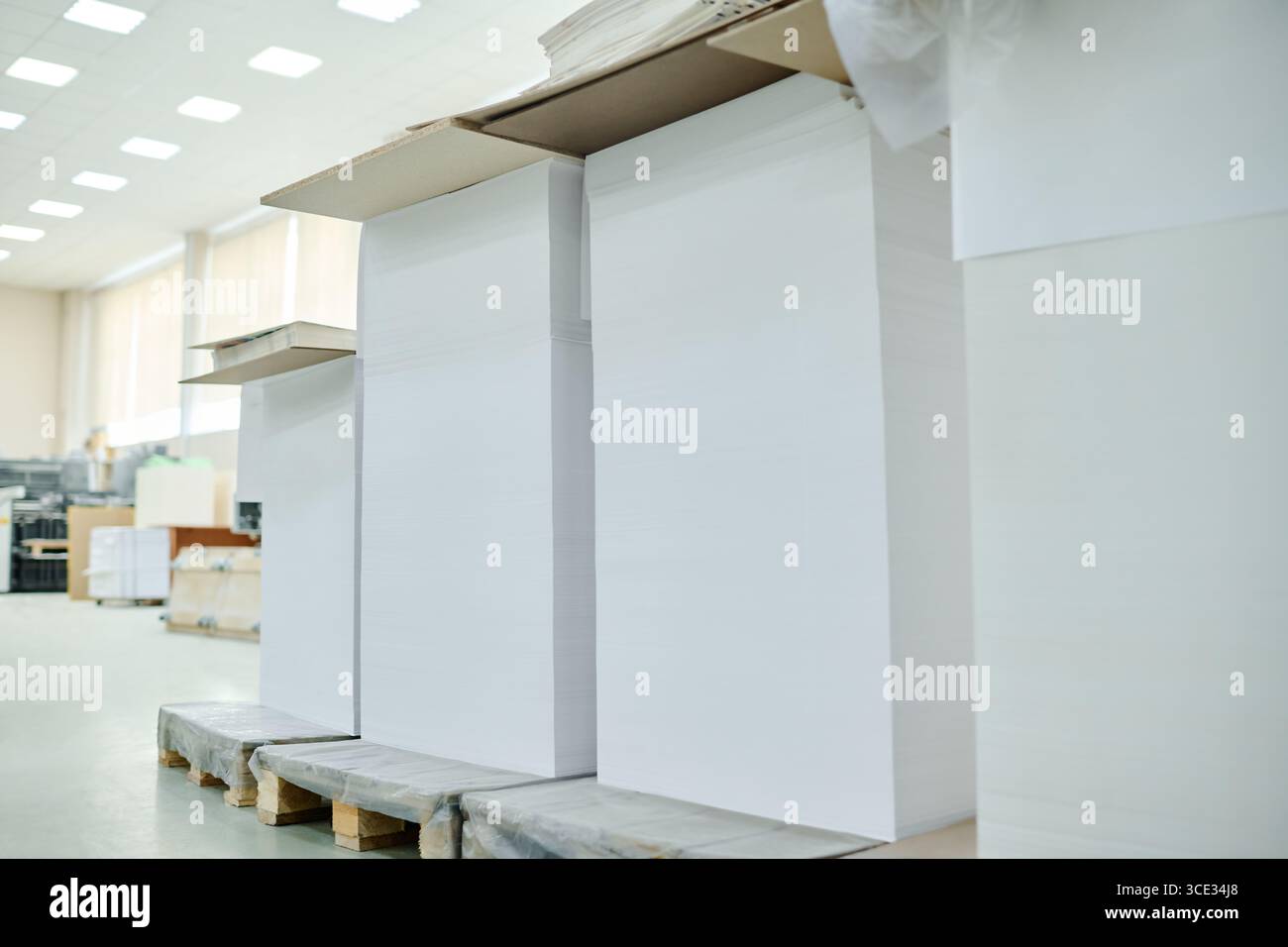 Keine Leute schossen von Haufen weißem Papier in modernen Druckereien, im Kopierraum Stockfoto