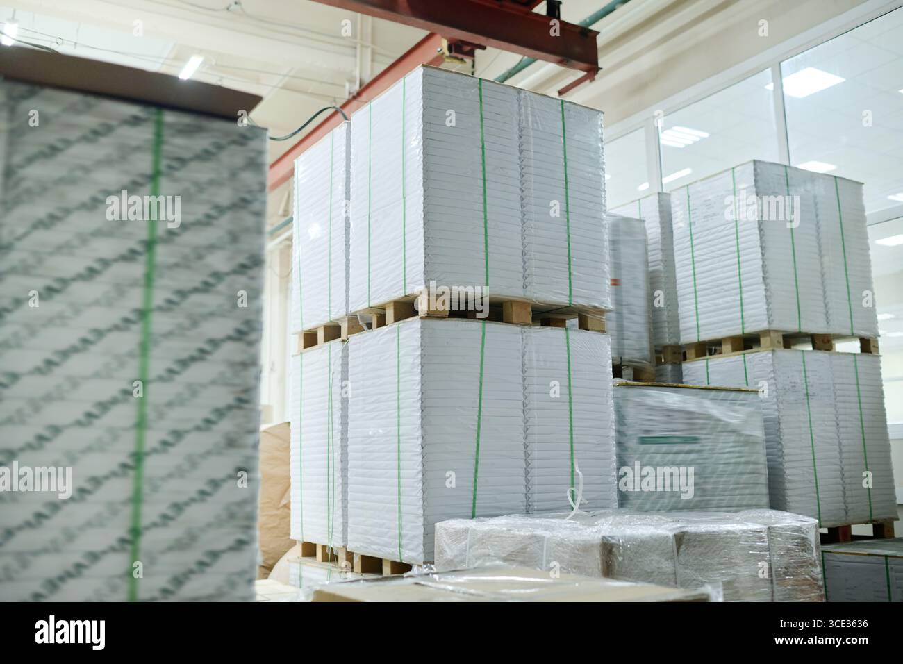 Keine Leute schossen auf Stapel von verpacktem weißem Papier in einem modernen Druckwarenlager, Kopierraum Stockfoto