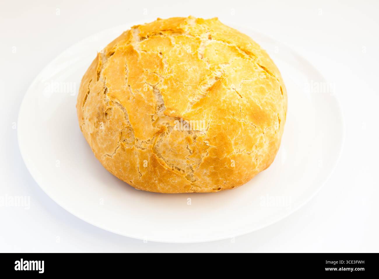 Rundes weißes Brot auf einer weißen Platte mit weißem Hintergrund. Stockfoto