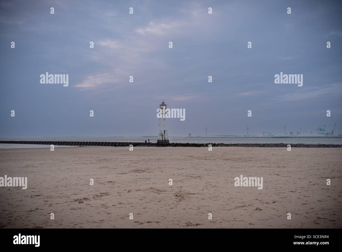 Das historische New Brighton Lighthouse in England, fotografiert an einem bewölkten Abend, während das weiche, verblassende Licht des Tages eine stimmungsvolle Atmosphäre erzeugt Stockfoto