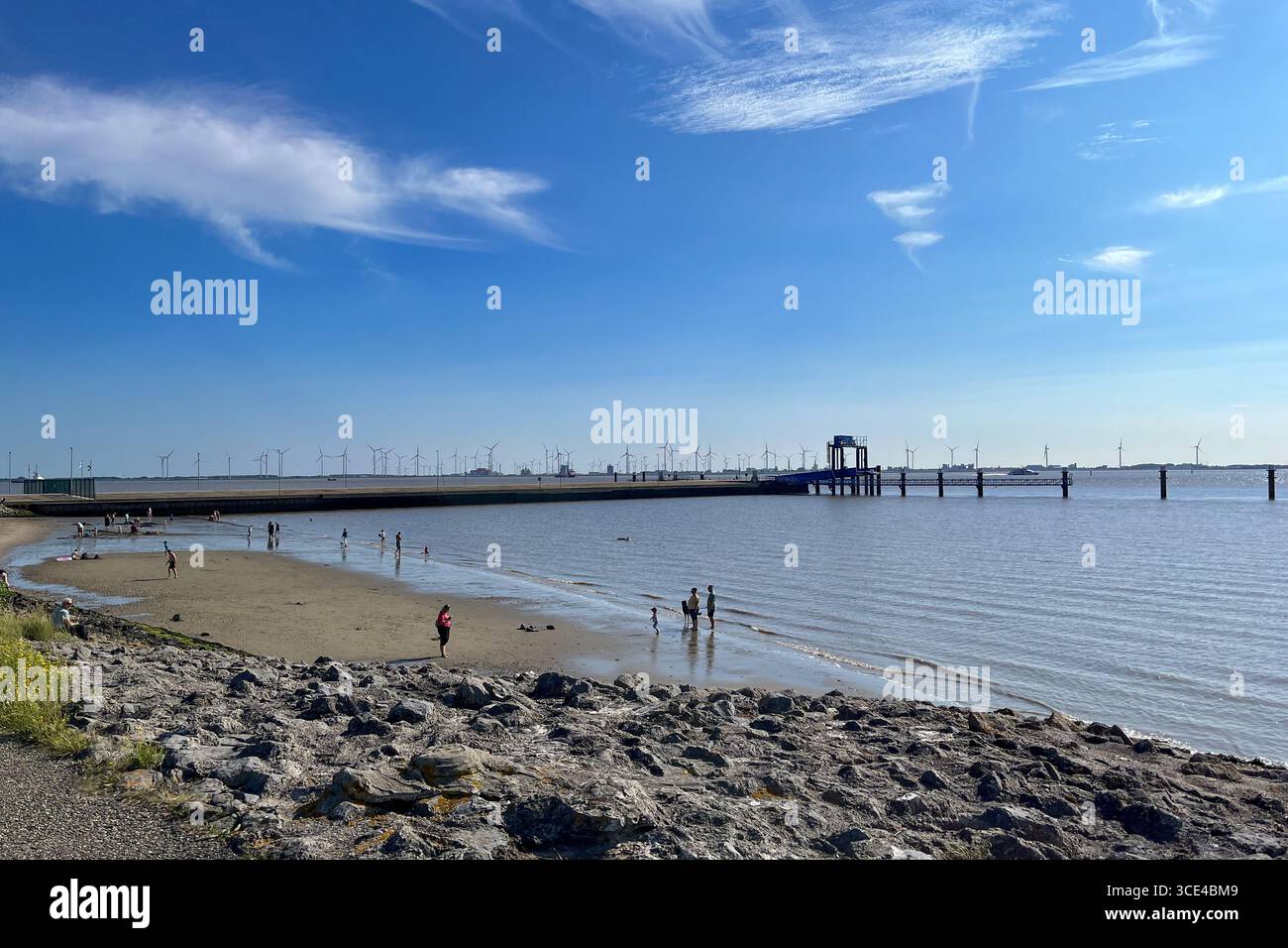 Klock, Deutschland - 12. August 2025: Das Klopfen in Ostfriesland an einem sonnigen Sommertag. Menschen, die baden, sonnen oder spazieren gehen. Stockfoto