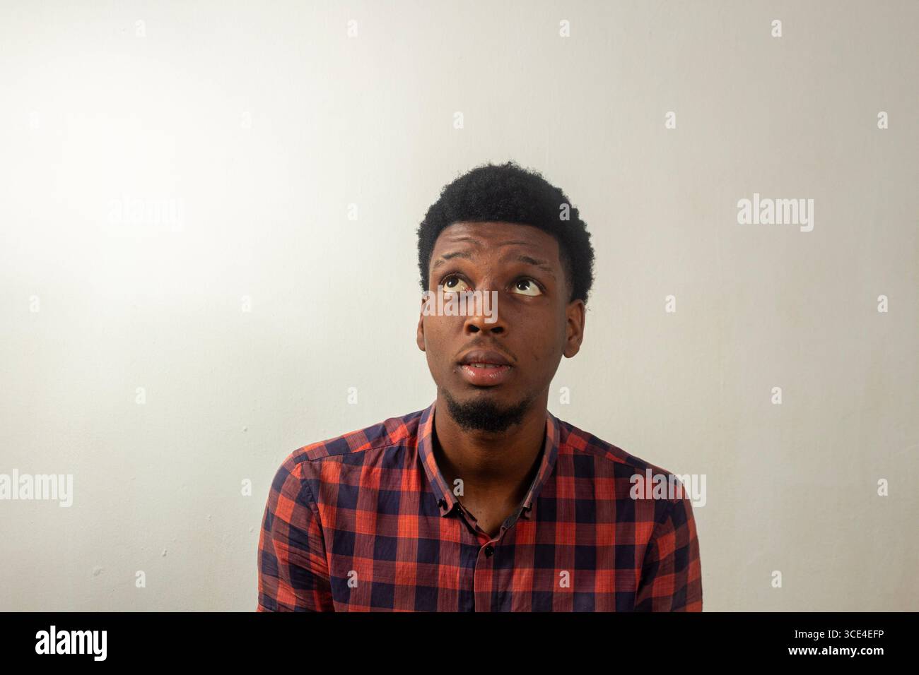 Vielseitige Sammlung ausdrucksstarker Porträts mit einem jungen Afrikaner in verschiedenen Posen und Emotionen vor einem sauberen Studio-Hintergrund Stockfoto