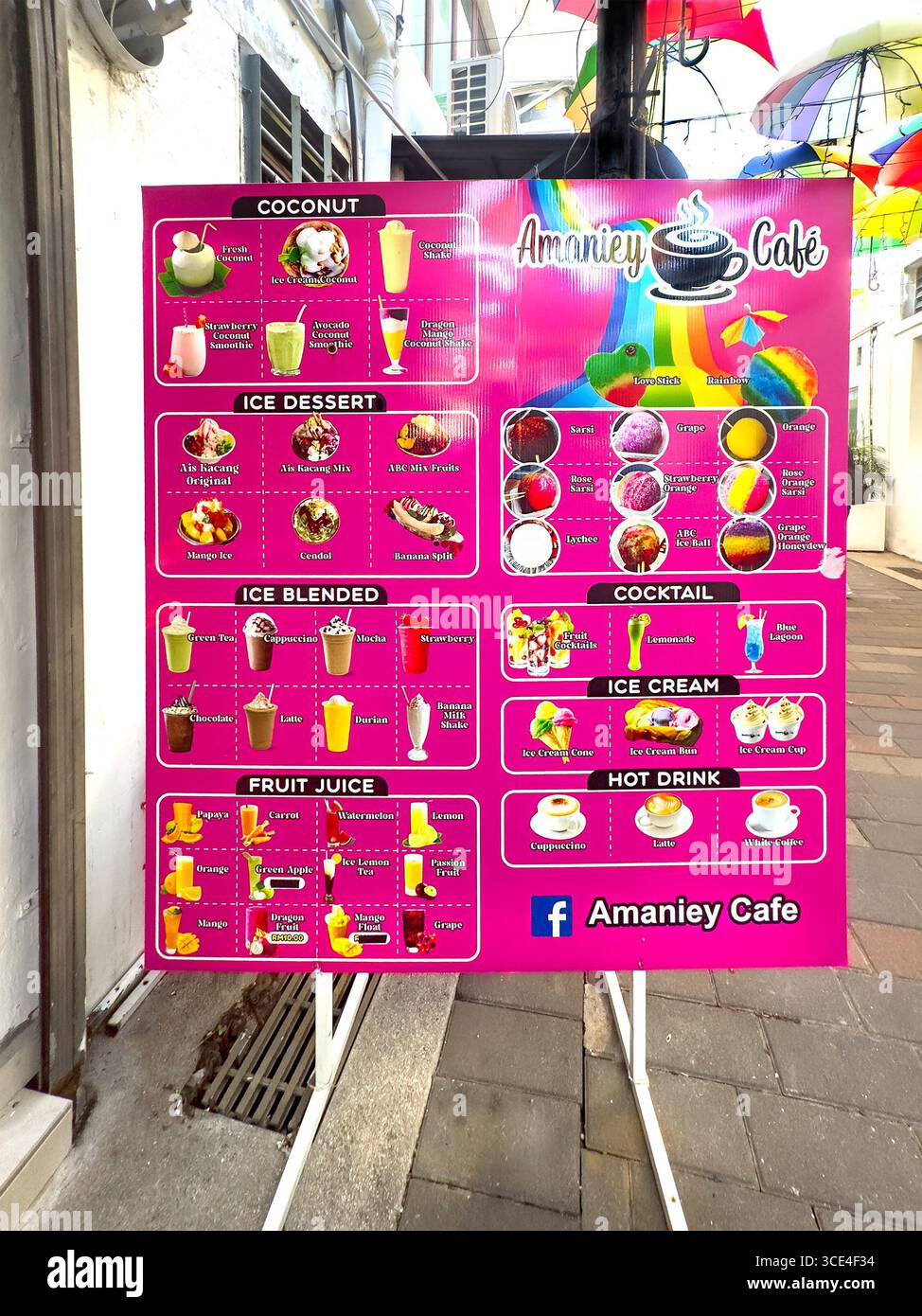 Farbenfrohe Menükarte vor dem Amaniey Cafe mit einer Auswahl an Kokosgetränken, Eisdesserts, Cocktails und Fruchtsäften. Malaysia - Smartphone-aufgenommenes Stockfoto