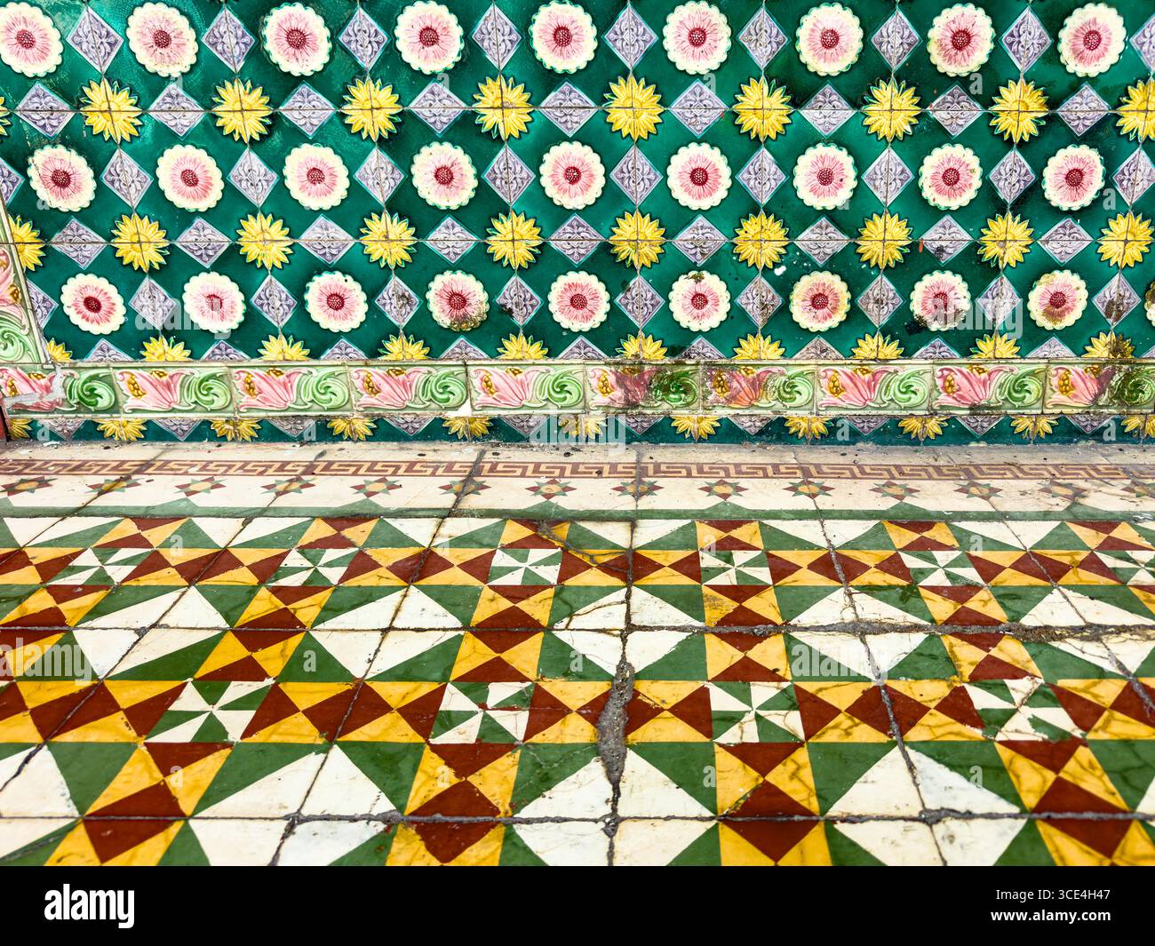 Farbenfrohe Fliesenboden- und Wandfliesen mit lebendigen geometrischen Mustern und Blumenmotiven in traditionellem Design Stockfoto