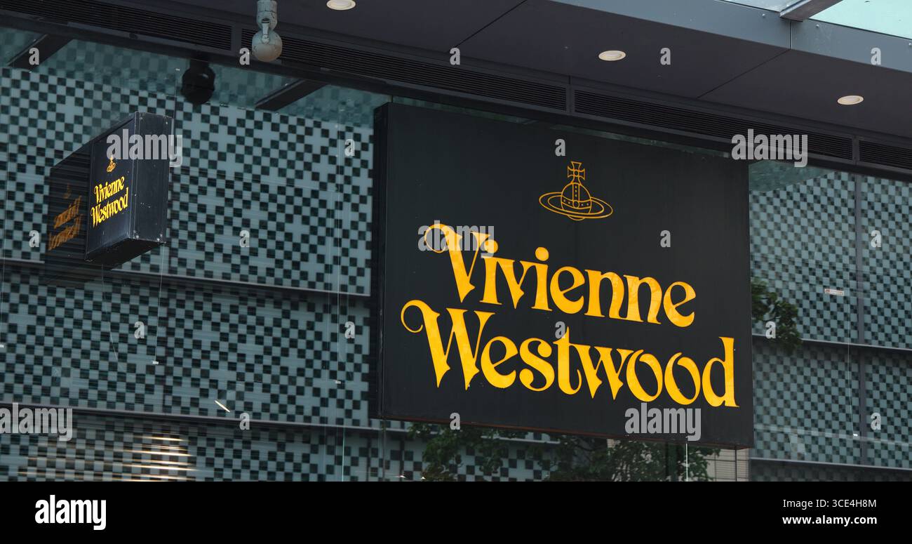 CARDIFF, Großbritannien - 8. AUGUST 2025 - Vivienne Westwood Ladenschilder mit goldenem Logo und Orgelemblem vor einer karierten Glasfassade in Cardiff, Wales Stockfoto