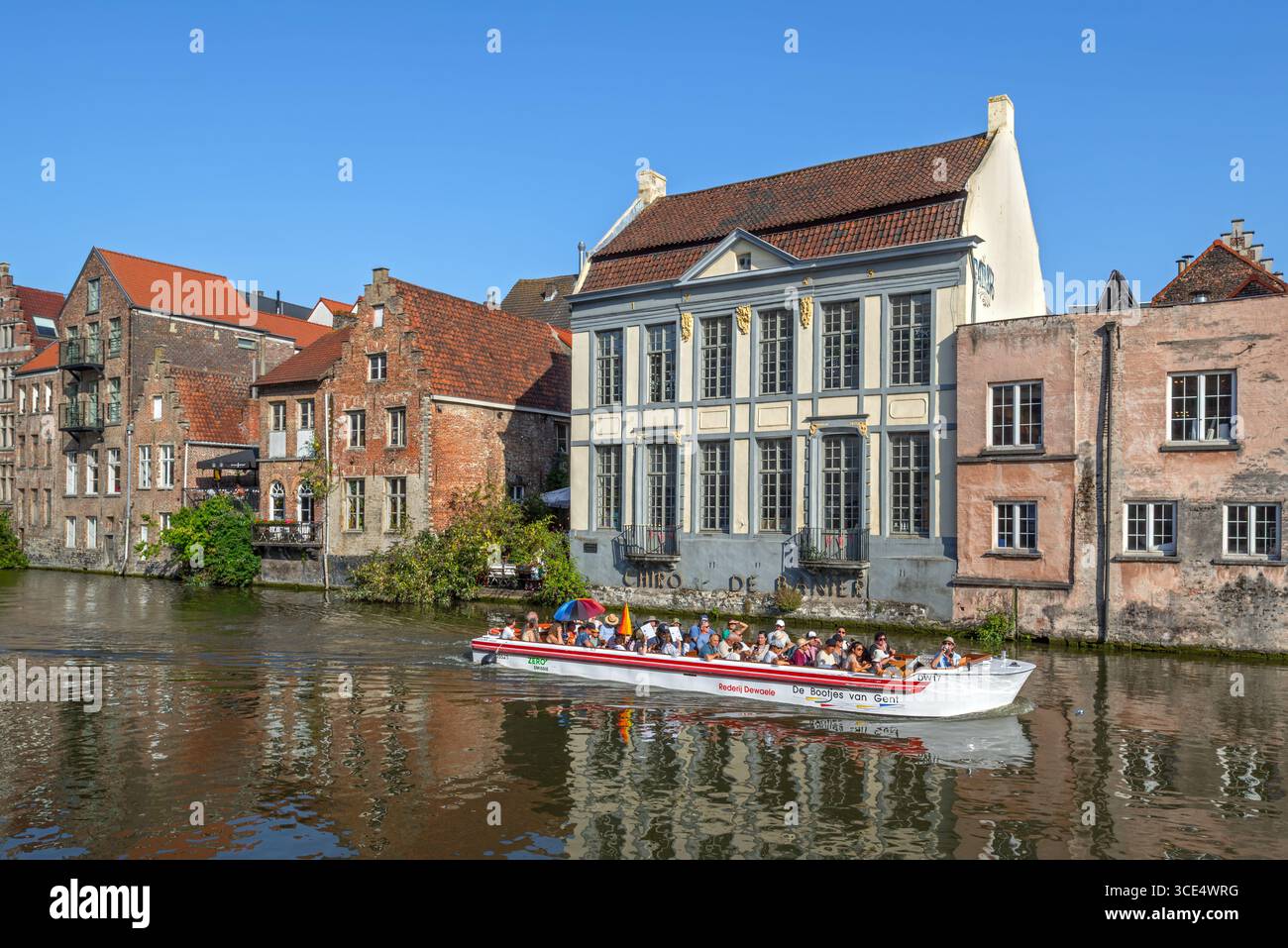Bootstour mit Touristen auf dem Fluss Leie/Lys entlang mittelalterlicher Häuser im historischen Stadtzentrum von Gent im Sommer, Ostflandern, Belgien Stockfoto