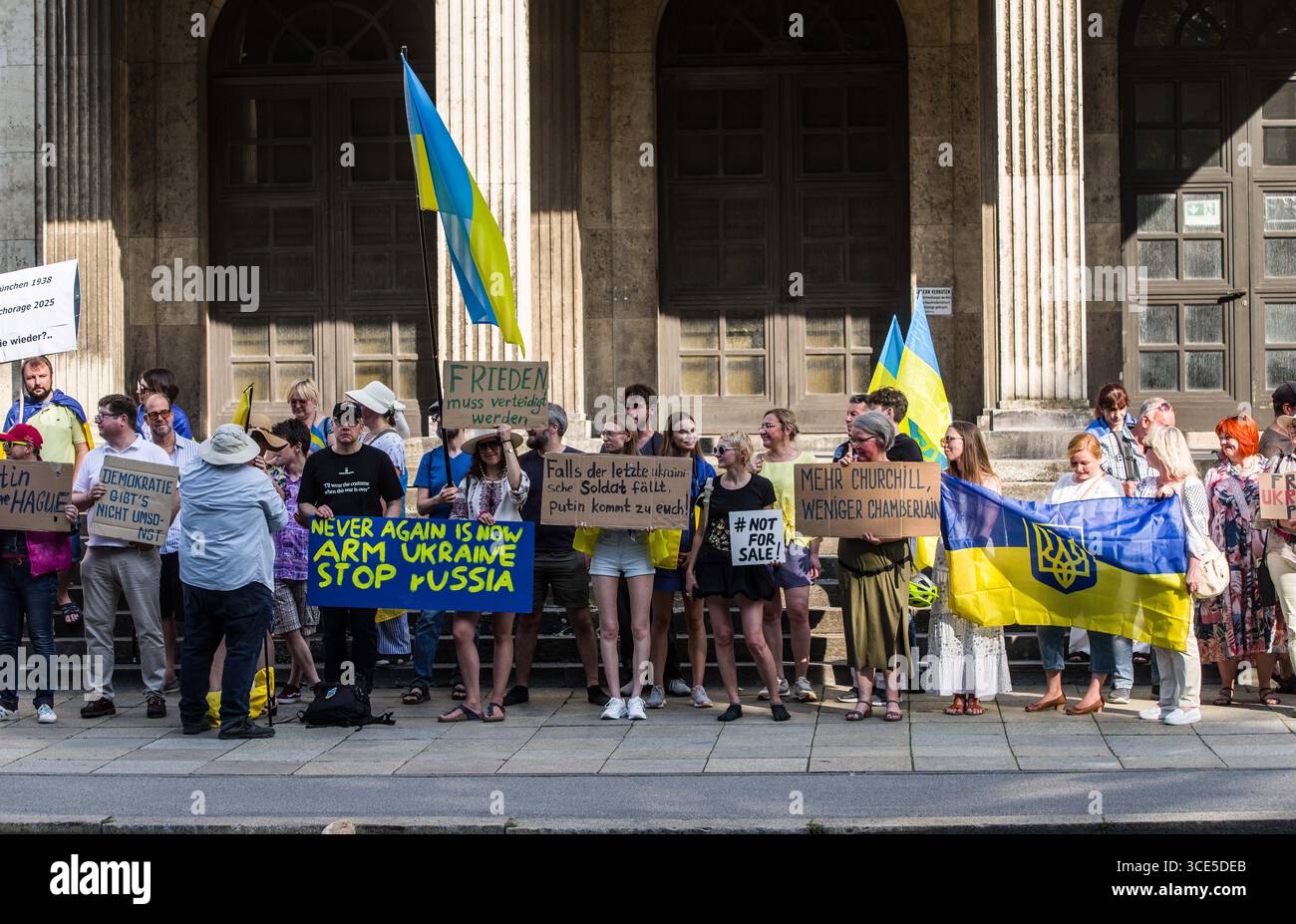 München, Bayern, Deutschland. August 2025. Zeitgleich mit dem Gipfel von Alaska 2025 zwischen Donald Trump und dem russischen Wladimir Putin warnten Ukrainer und Deutsche in München am Ort des Münchner Abkommens von 1938 die westliche Allianz vor einem gefährlichen Beschwichtigungsszenario, ähnlich dem, als die Weltmächte Hitler erlaubten, das Sudetenland anzunektieren, was letztlich den Zweiten Weltkrieg nicht verhinderte. Andere sprachen von Jalta 1945, als Putin und Trump darüber diskutieren, das Land der Ukraine ohne die Anwesenheit von Zelenskyj zu teilen. Historiker und Analysten warnen die westlichen Mächte, dass Putin jeden Waffenstillstand und einen nutzen wird Stockfoto