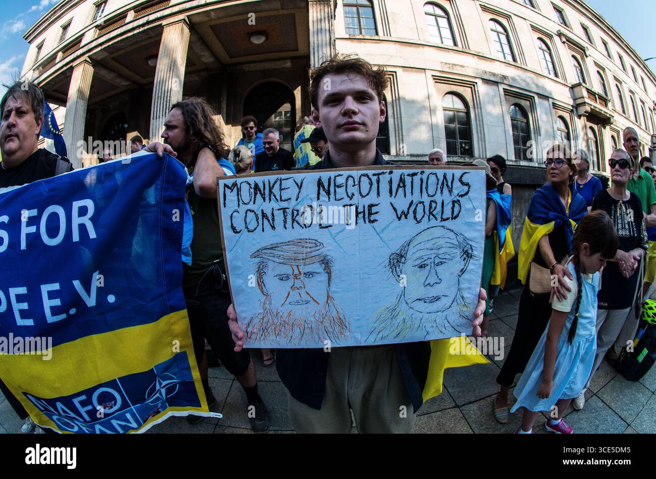 München, Bayern, Deutschland. August 2025. Die skizzierten Gesichter von Trump und Putin auf einem Schild, das den Zynismus des Alaska-Gipfels ausdrückt. Zeitgleich mit dem Gipfel von Alaska 2025 zwischen Donald Trump und dem russischen Wladimir Putin warnten Ukrainer und Deutsche in München am Ort des Münchner Abkommens von 1938 die westliche Allianz vor einem gefährlichen Beschwichtigungsszenario, ähnlich dem, als die Weltmächte Hitler erlaubten, das Sudetenland anzunektieren, was letztlich den Zweiten Weltkrieg nicht verhinderte. Andere sprachen von Jalta 1945, als Putin und Trump darüber diskutieren, das Land der Ukraine ohne die Anwesenheit von Zelenskyj zu teilen. Hist Stockfoto