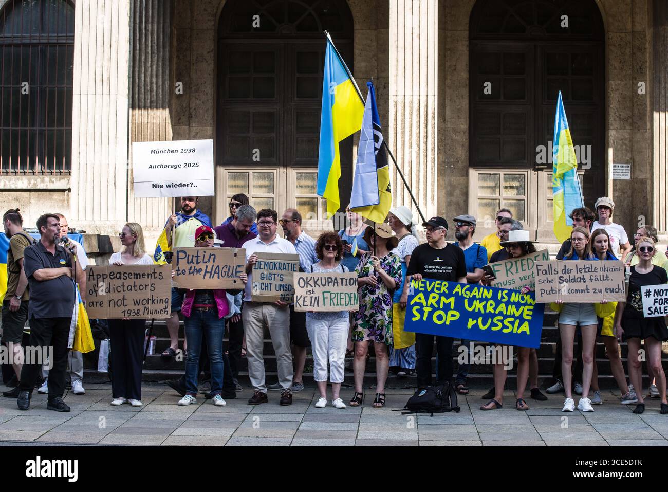München, Bayern, Deutschland. August 2025. Zeitgleich mit dem Gipfel von Alaska 2025 zwischen Donald Trump und dem russischen Wladimir Putin warnten Ukrainer und Deutsche in München am Ort des Münchner Abkommens von 1938 die westliche Allianz vor einem gefährlichen Beschwichtigungsszenario, ähnlich dem, als die Weltmächte Hitler erlaubten, das Sudetenland anzunektieren, was letztlich den Zweiten Weltkrieg nicht verhinderte. Andere sprachen von Jalta 1945, als Putin und Trump darüber diskutieren, das Land der Ukraine ohne die Anwesenheit von Zelenskyj zu teilen. Historiker und Analysten warnen die westlichen Mächte, dass Putin jeden Waffenstillstand und einen nutzen wird Stockfoto