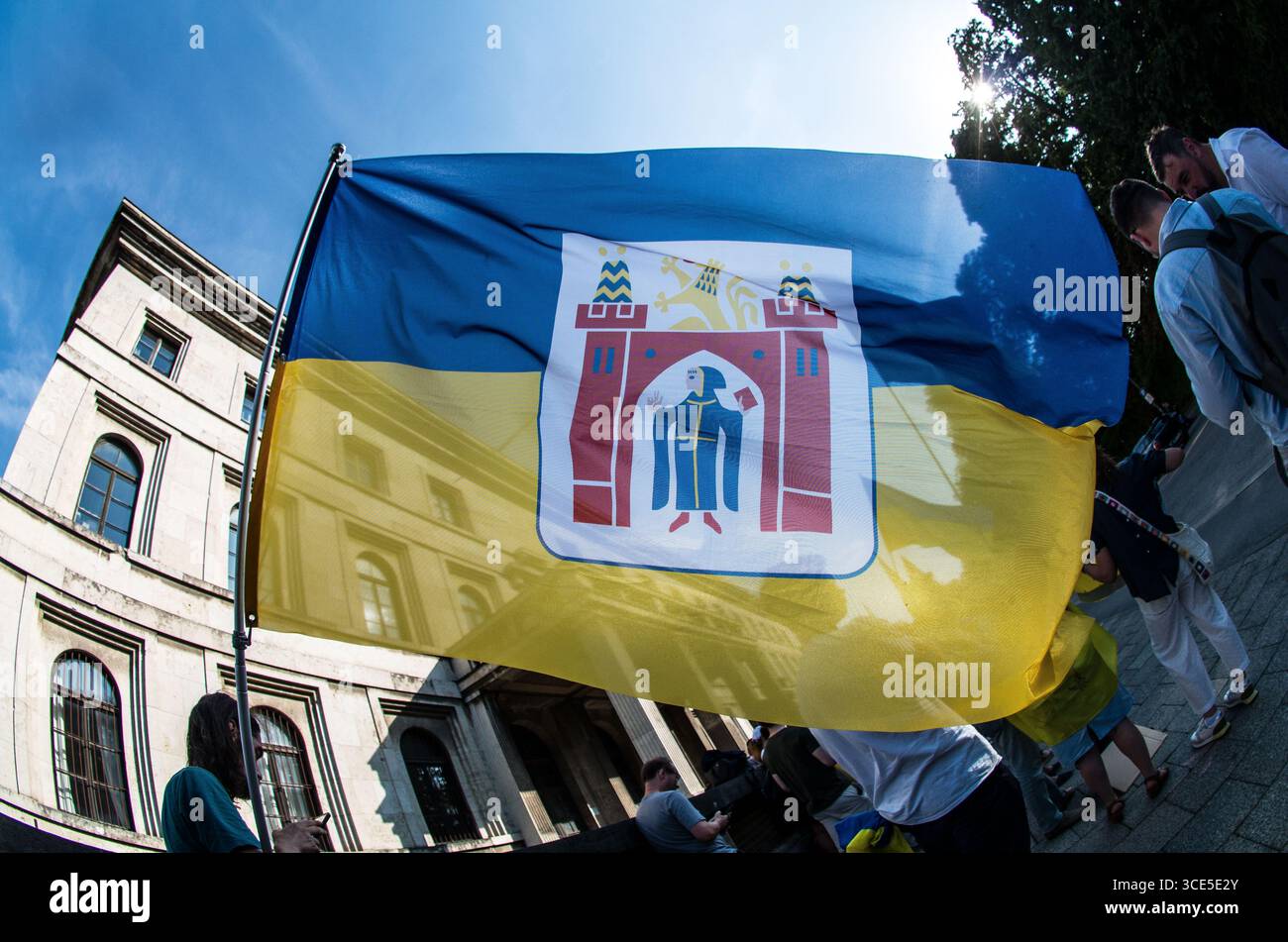 München, Bayern, Deutschland. August 2025. Die Flaggen von München und der Ukraine verschmolzen und symbolisieren die Unterstützung. Zeitgleich mit dem Gipfel von Alaska 2025 zwischen Donald Trump und dem russischen Wladimir Putin warnten Ukrainer und Deutsche in München am Ort des Münchner Abkommens von 1938 die westliche Allianz vor einem gefährlichen Beschwichtigungsszenario, ähnlich dem, als die Weltmächte Hitler erlaubten, das Sudetenland anzunektieren, was letztlich den Zweiten Weltkrieg nicht verhinderte. Andere sprachen von Jalta 1945, als Putin und Trump darüber diskutieren, das Land der Ukraine ohne die Anwesenheit von Zelenskyj zu teilen. Historiker und Analys Stockfoto