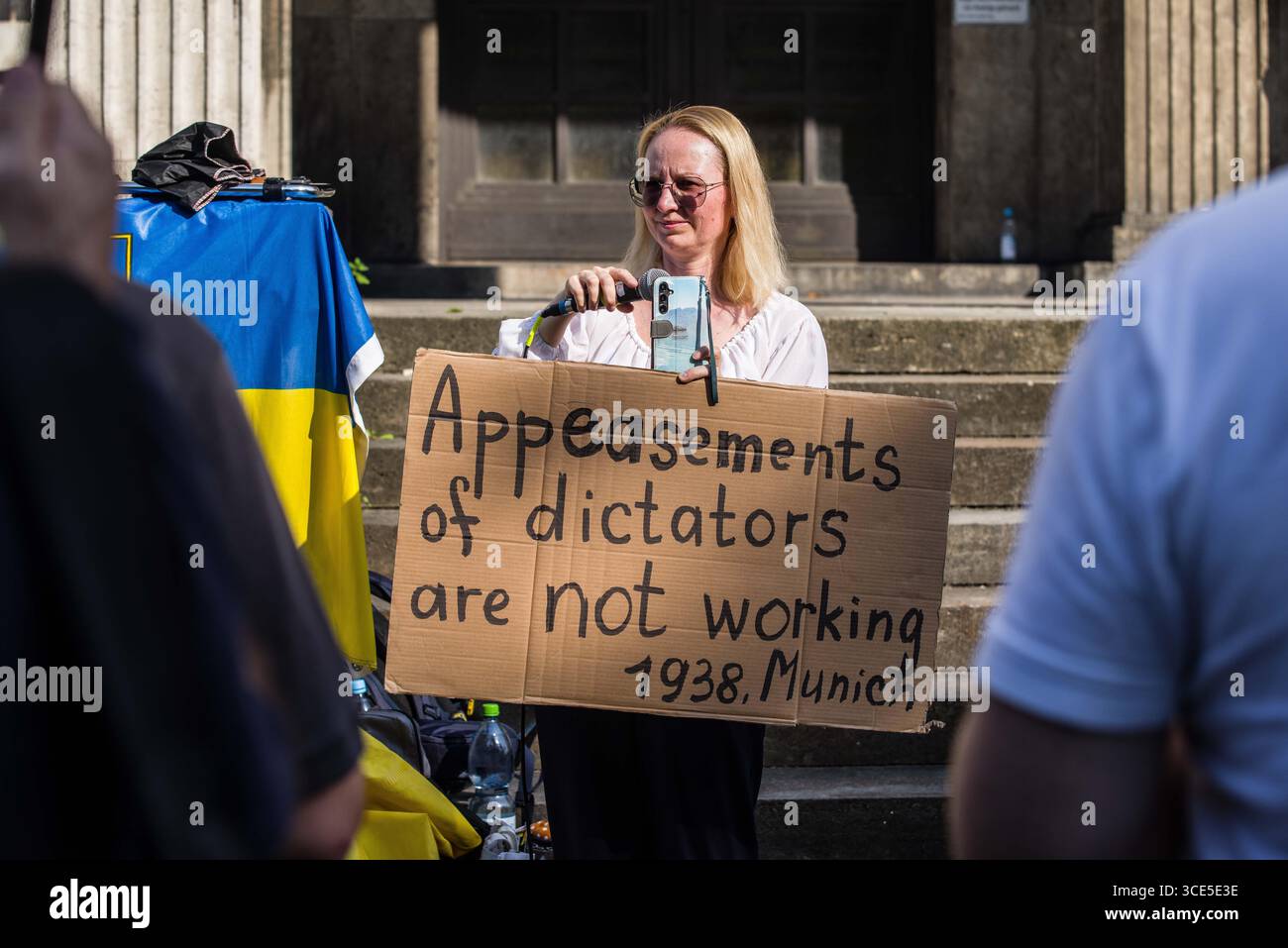 München, Bayern, Deutschland. August 2025. Zeitgleich mit dem Gipfel von Alaska 2025 zwischen Donald Trump und dem russischen Wladimir Putin warnten Ukrainer und Deutsche in München am Ort des Münchner Abkommens von 1938 die westliche Allianz vor einem gefährlichen Beschwichtigungsszenario, ähnlich dem, als die Weltmächte Hitler erlaubten, das Sudetenland anzunektieren, was letztlich den Zweiten Weltkrieg nicht verhinderte. Andere sprachen von Jalta 1945, als Putin und Trump darüber diskutieren, das Land der Ukraine ohne die Anwesenheit von Zelenskyj zu teilen. Historiker und Analysten warnen die westlichen Mächte, dass Putin jeden Waffenstillstand und einen nutzen wird Stockfoto