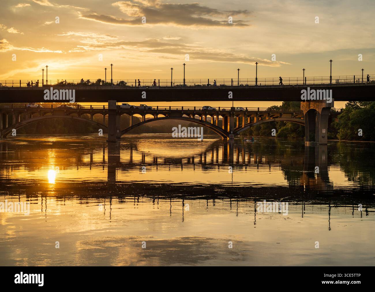 Die Fußgängerbrücke Pfluger und der historische Lamar Boulevard dahinter spiegeln sich im goldenen Licht in Austin Texas wider Stockfoto