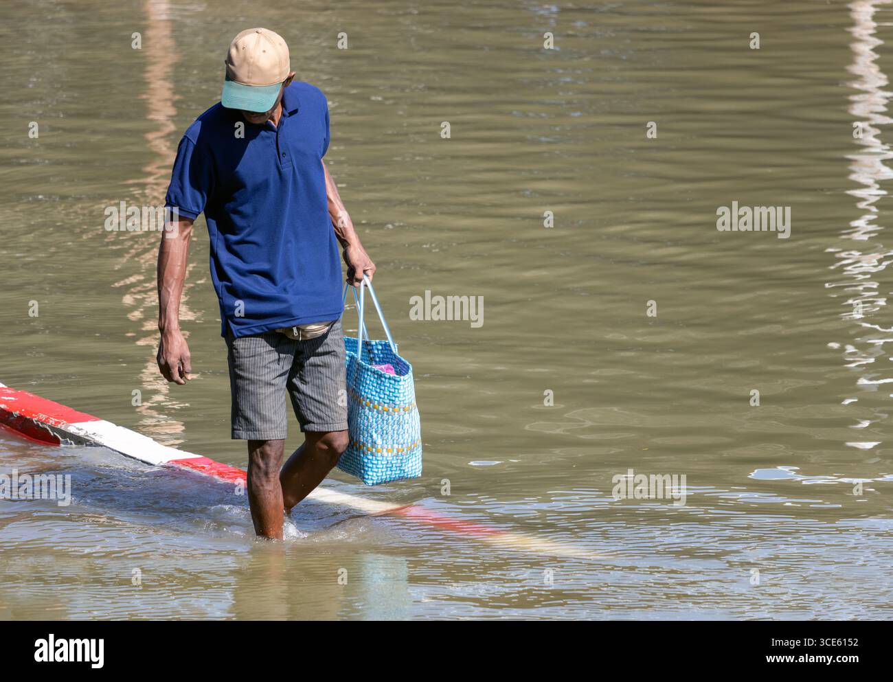 Ein Mann watet durch eine überflutete Straße, Bangkok, Thailand Stockfoto