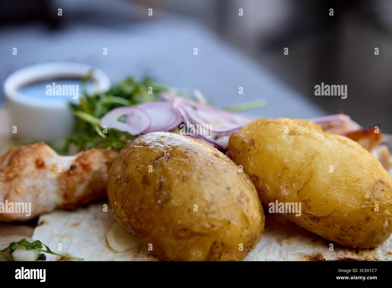 Gericht mit gekochten Kartoffeln mit gegrillten Hähnchenspießen und Sauce Stockfoto