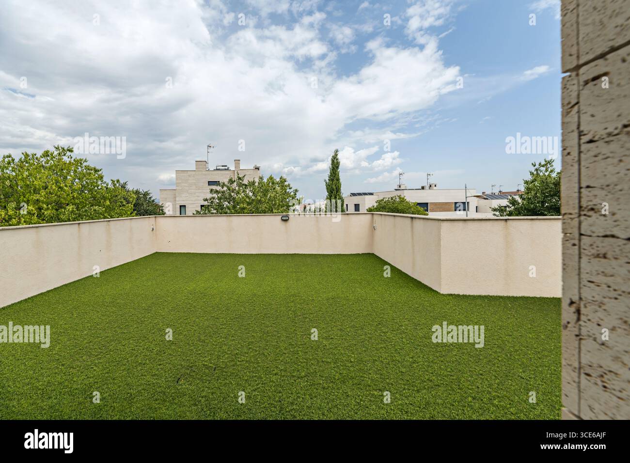 Private Penthaus-Terrasse mit Marmorwänden und frühlinggrünem Kunststoffdeck Stockfoto