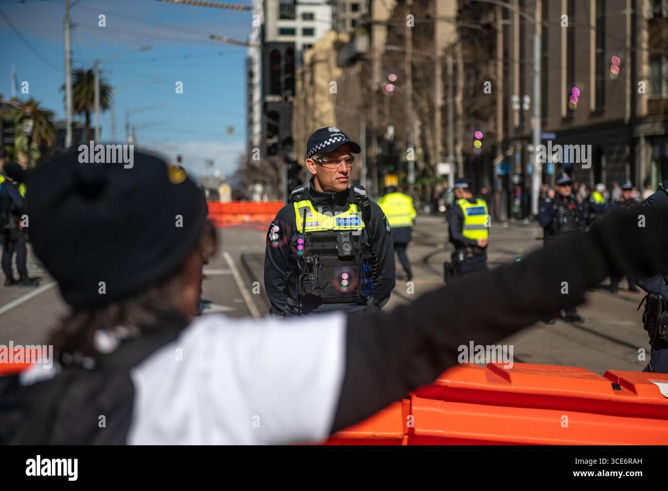 August 2025, Melbourne, Australien. Ein Transgender-Rechte-Aktivist bläst Blasen vor einer Polizeilinie während eines Gegenprotests gegen eine Anti-Trans-Kundgebung "Frauen werden sprechen". Quelle: Jay Kogler/Alamy Live News Stockfoto