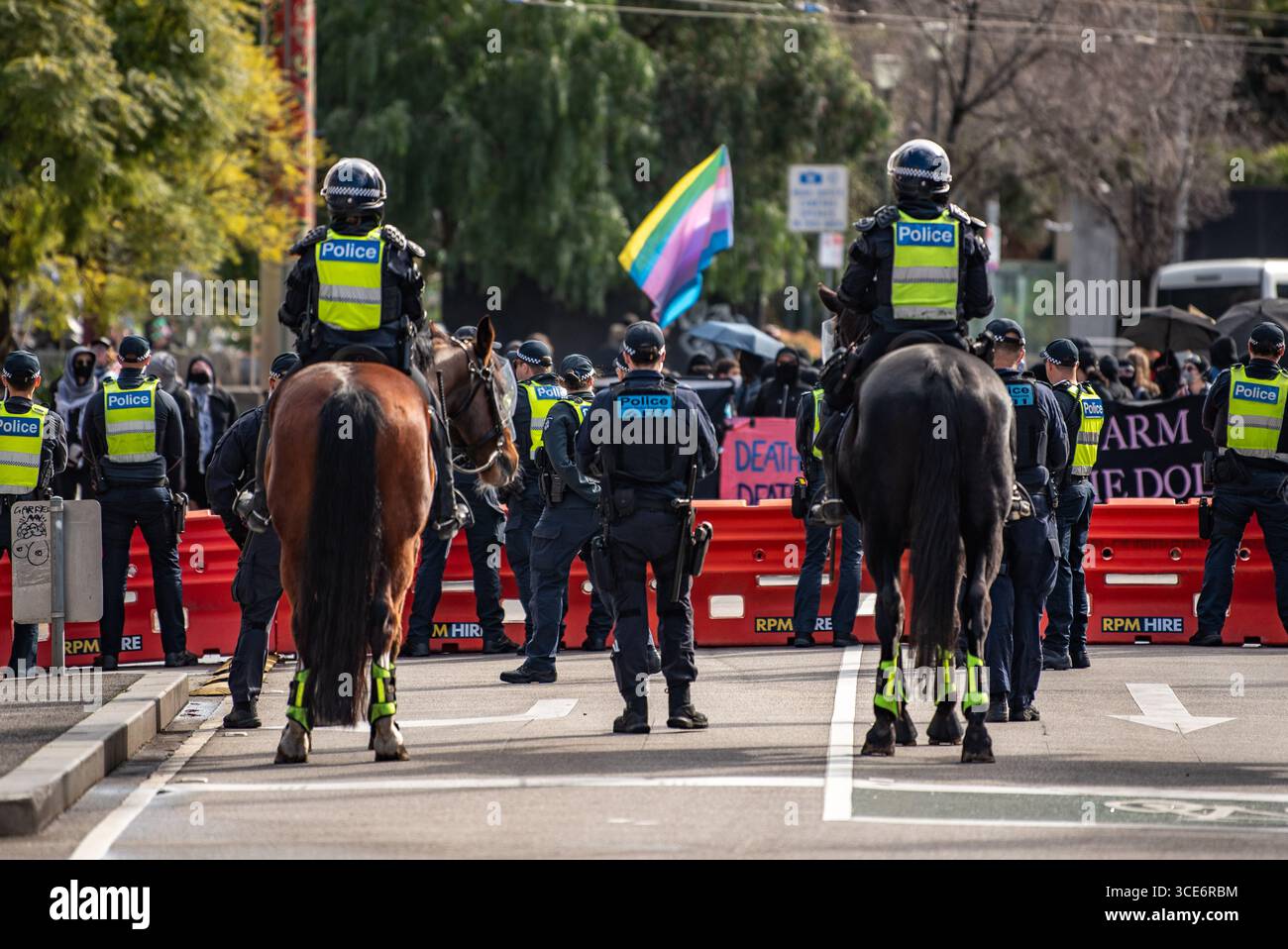August 2025, Melbourne, Australien. Transgender-Rechteaktivisten schwingen Fahnen vor der Polizei während eines Gegenprotests gegen eine Anti-Trans-Kundgebung „Women will Speak“. Quelle: Jay Kogler/Alamy Live News Stockfoto