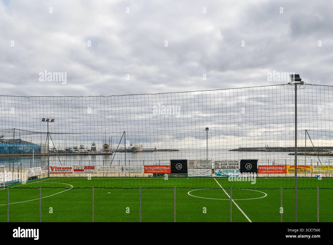 Erhöhter Blick auf das Fußballfeld des ASD Junior Soccer, mit Blick auf den Sandstrand des Seebades, an einem bewölkten Wintertag, Sanremo, Italien Stockfoto