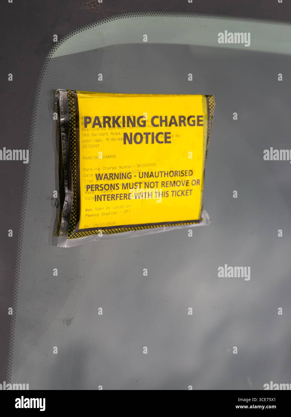 Gelber Hinweis auf Parkgebühren auf der Windschutzscheibe des Autos, Bahnhof Pewsey, Wiltshire, England, Großbritannien Stockfoto