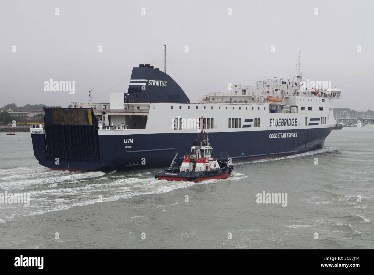 Ein Schlepper eskortiert den Passagier und die Frachtrolle auf der Fähre MV LIVIA in Richtung Hafen Terminal. Stockfoto