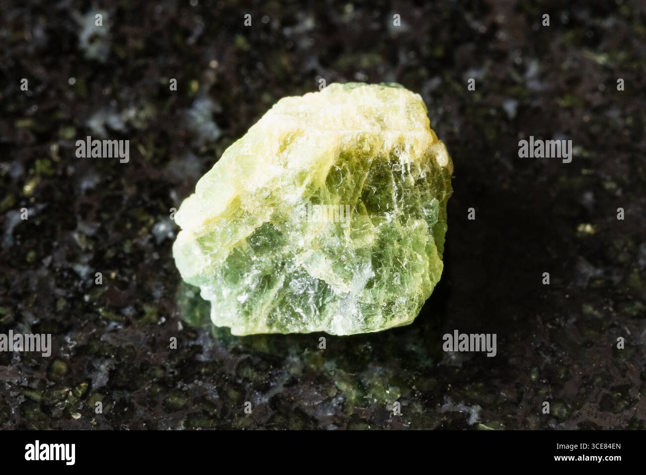 Probe eines rohen gelb grünen berylminerals auf schwarzem Granithintergrund aus der Nähe von Tansania Stockfoto