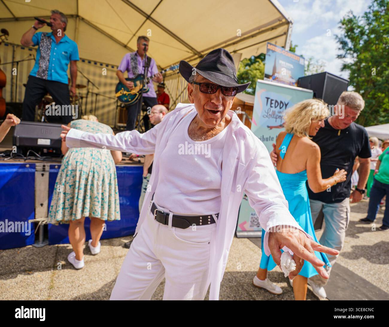 Bad Nauheim, Deutschland. August 2025. Festivalbesucher tanzen zu den Klängen von Elvis Presley vor der Bühne. Bis 17. August 2025 feiert der Kurort „The King of Rock'n'Roll“ auf dem 23. Europäischen Elvis-Festival. Elvis Presley war während seines Militärdienstes 1958 im benachbarten Friedberg stationiert und lebte in dieser Zeit in Bad Nauheim. Darlegung: Andreas Arnold/dpa/Alamy Live News Stockfoto