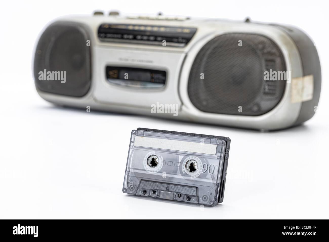 Ein Vintage-Kassettenband, transparenter Kunststoff und ein tragbarer Retro-Audioplayer wecken Nostalgie, Musikerinnerungen und klassischen analogen Sound Stockfoto