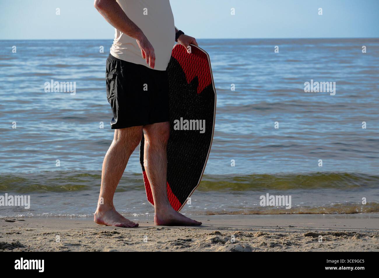 Mann mit Surfbrett am Strand, Nahaufnahme. Stockfoto