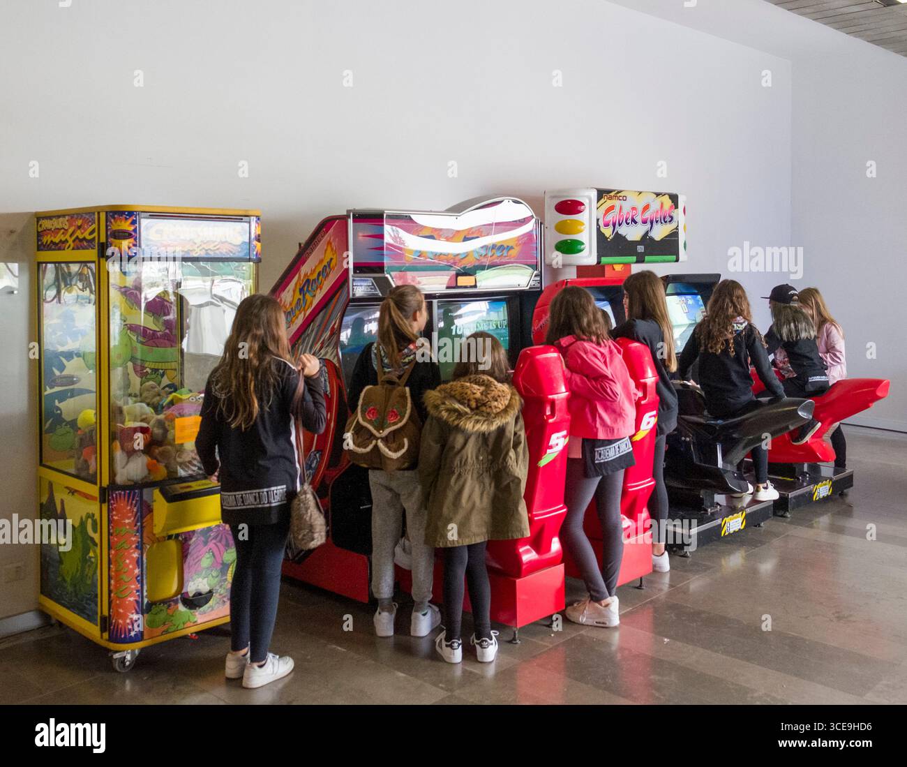 Jugendliche Mädchen, die an elektronischen Videospielen in der Raststätte an der Autobahn A2, São João de Negrilhos, Beja, Alentejo, Portugal, herumstehen Stockfoto